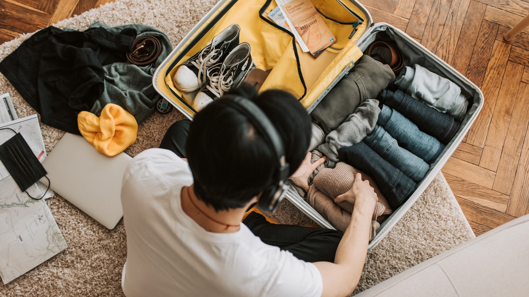 A man packing a carry on sized suit case